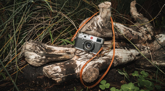 A handcrafted leather camera strap displayed alongside a mass-produced option, highlighting the superior quality, unique design, and craftsmanship of handmade straps.