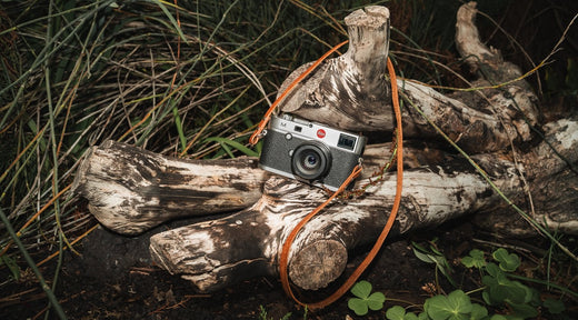 A handcrafted leather camera strap displayed alongside a mass-produced option, highlighting the superior quality, unique design, and craftsmanship of handmade straps.