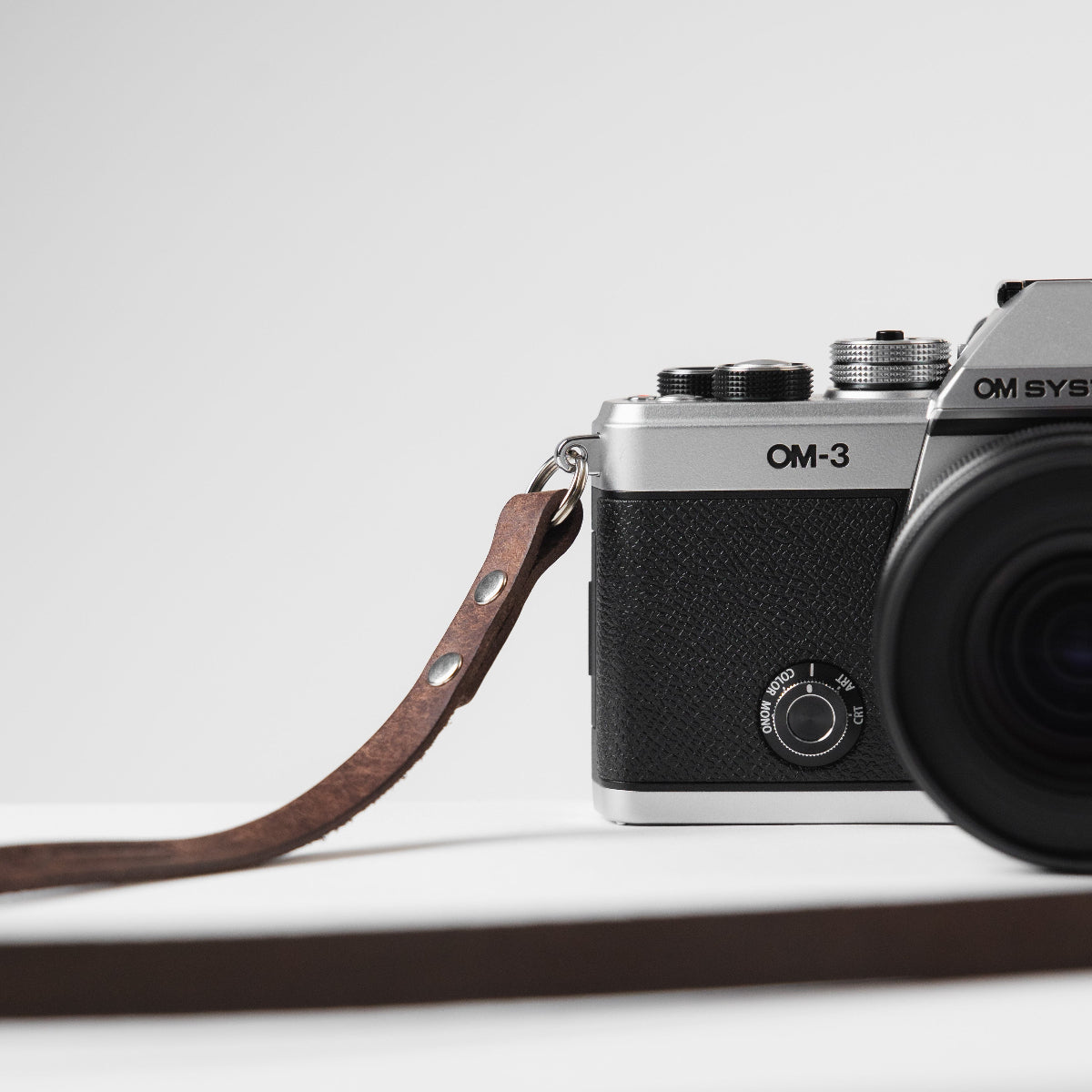 New OM SYSTEM OM-3 camera with dark brown Arch Appearance leather camera strap