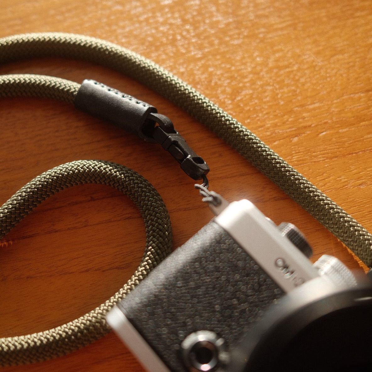 om system om-3 camera connected to a quick release rope camera strap